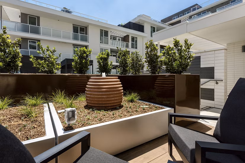 THEO: Stylish patio with modern seating and lush greenery in luxury apartments