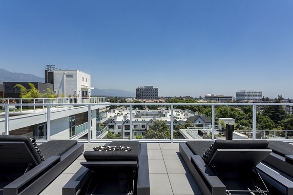Expansive patio at THEO featuring modern outdoor seating and lush greenery, perfect for relaxation and social gatherings