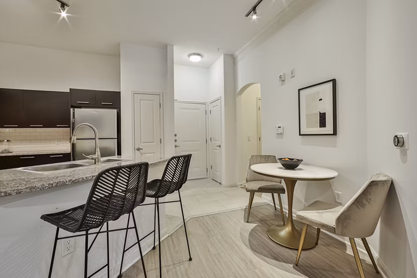 Dining area with elegant wooden table and modern chairs at Broadstone Toscano Apartments, luxury living space in Houston