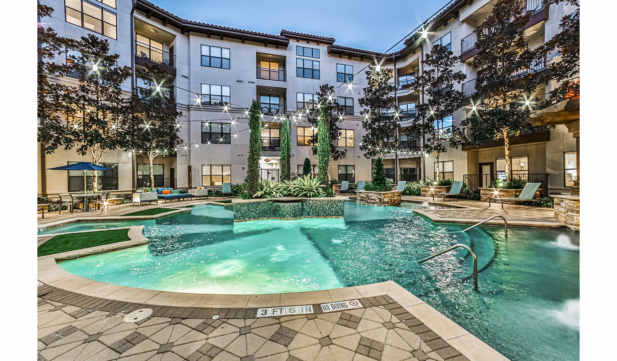 Outdoor pool surrounded by lush greenery at Broadstone Toscano Apartments, offering luxury relaxation and leisure