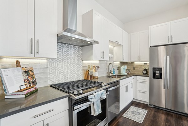 Kitchen with modern appliances and granite countertops at The Cove Apartments