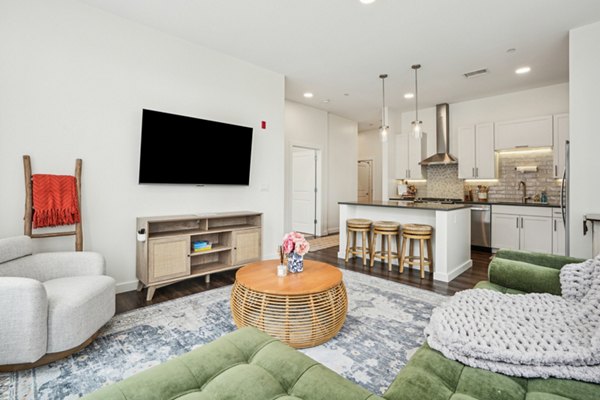 Living room featuring modern decor and large windows at The Cove Apartments in an elegant Greystar community