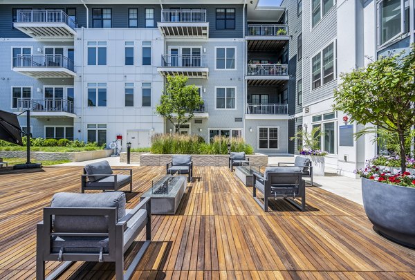 Modern outdoor patio with seating and table featuring a sunset view at luxury apartments
