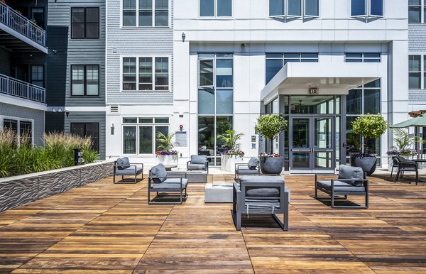 Patio with comfortable seating and lush greenery at The Cove Apartments, a Greystar luxury community