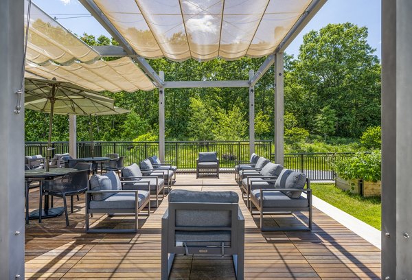 The Cove Apartments: Cozy outdoor patio featuring seating and greenery