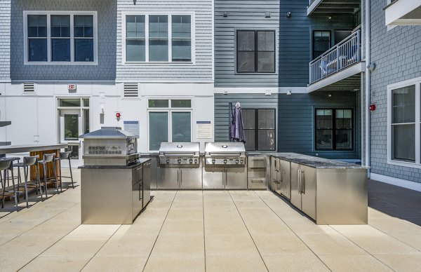 Grill area with modern patio furniture at The Cove Apartments