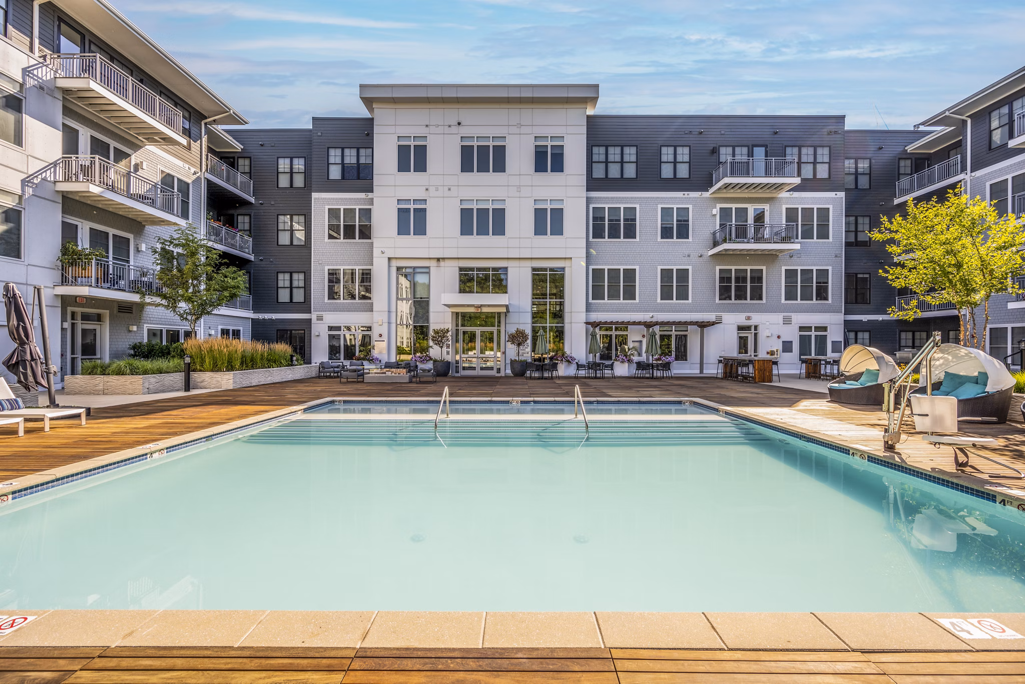 The Cove Apartments: Luxurious pool with lounging areas and scenic views
