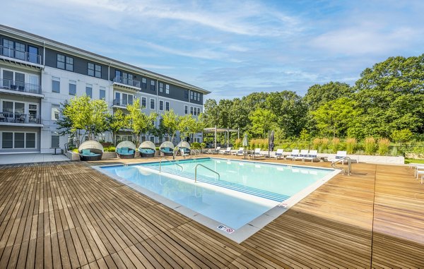 Relaxing pool area with lounge chairs at The Cove Apartments