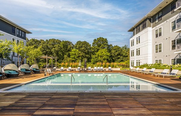 Modern outdoor pool area at The Cove Apartments, a luxury community by Greystar, offering relaxation and leisure with stylish deck chairs and poolside views