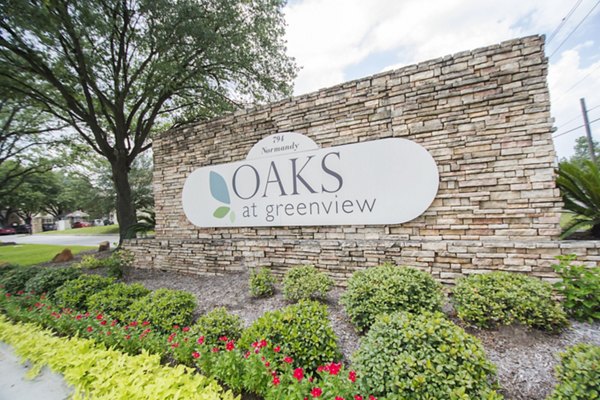Oaks at Greenview Apartments: Elegant signage amidst lush landscaping highlighting luxury living