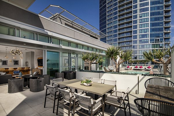 The Current Apartments: Modern patio with stylish seating and lush greenery