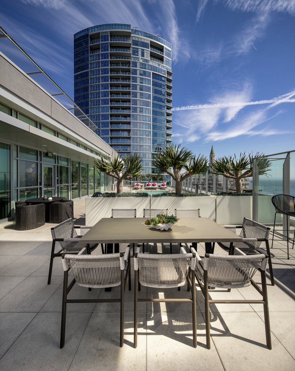 Modern patio with comfortable seating at The Current Apartments overlooking city skyline