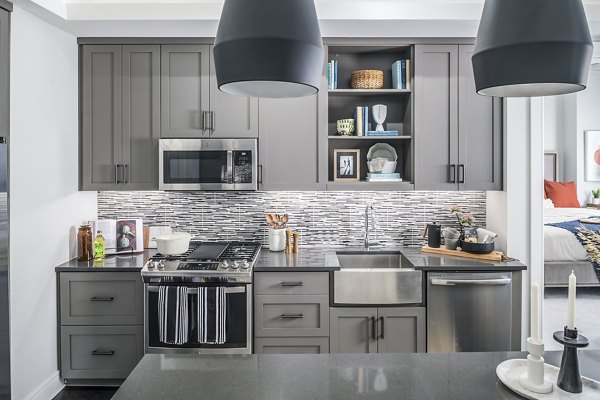 Modern kitchen featuring stainless steel appliances and granite countertops at The Ryan Apartments