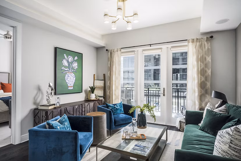 Cozy living room with modern decor and large windows at The Ryan Apartments: luxury Greystar rental in vibrant urban setting