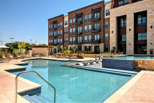 Infinity pool with lounge chairs at The Silverlake Apartments, offering a luxury retreat in a Greystar-managed community