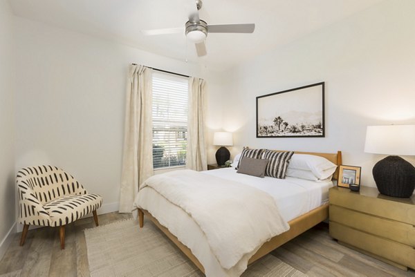 Cozy bedroom with modern decor at ORA Apartments offering luxury living in a premium Greystar community