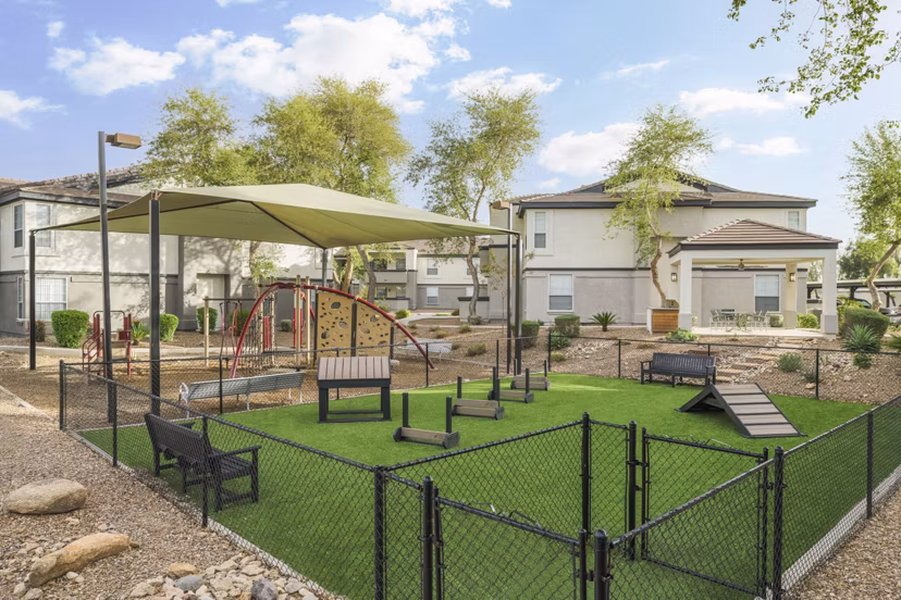 Dog-friendly park at ORA Apartments featuring agility equipment and green space for luxury pet amenities