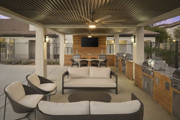 Outdoor grill area with modern seating at ORA Apartments, a luxury community by Greystar
