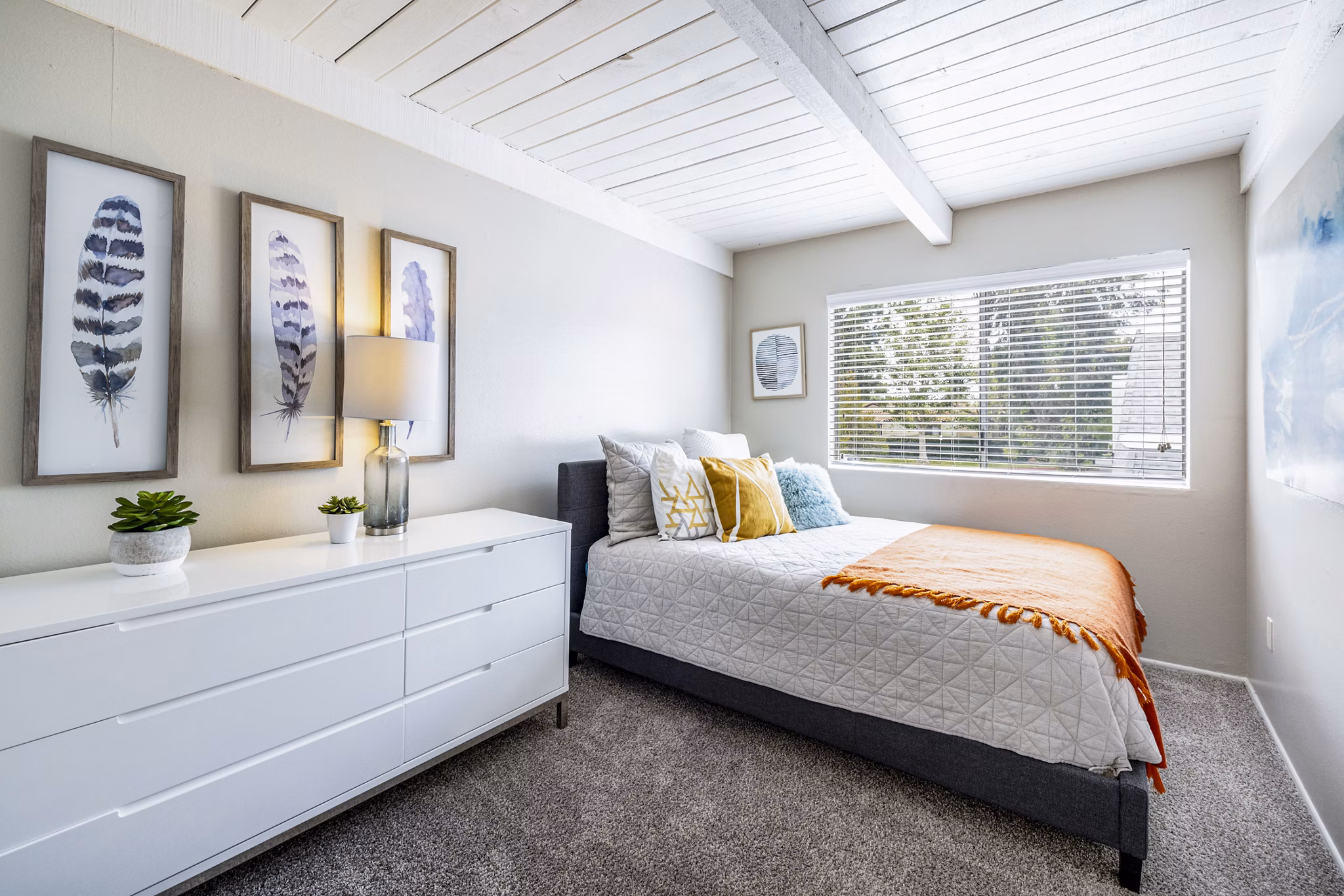 Bedroom with modern furnishings and natural light at Lexington Townhomes Apartments, luxury living by Greystar
