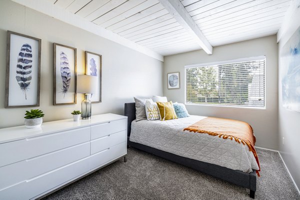 Bedroom with modern furnishings and natural light at Lexington Townhomes Apartments, luxury living by Greystar