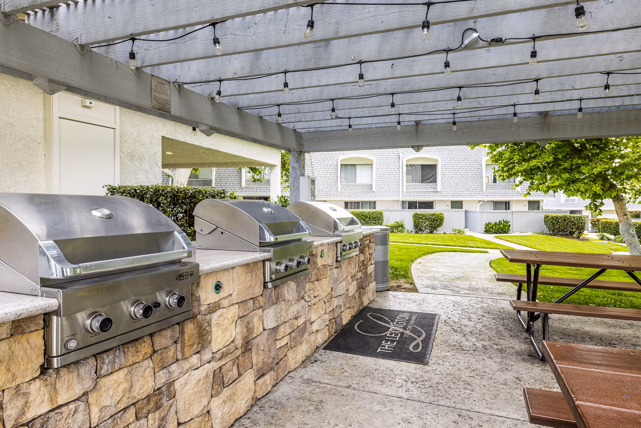 Grill area with seating on patio at Lexington Townhomes Apartments