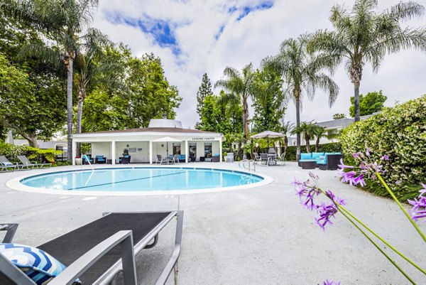 Resort-style pool with lounge chairs at Lexington Townhomes Apartments
