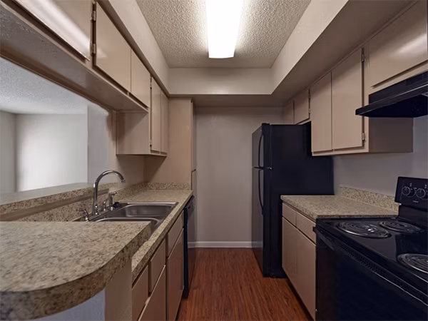 Modern kitchen with stainless steel appliances at Scotland Yard Apartments, featuring sleek countertops and ample storage