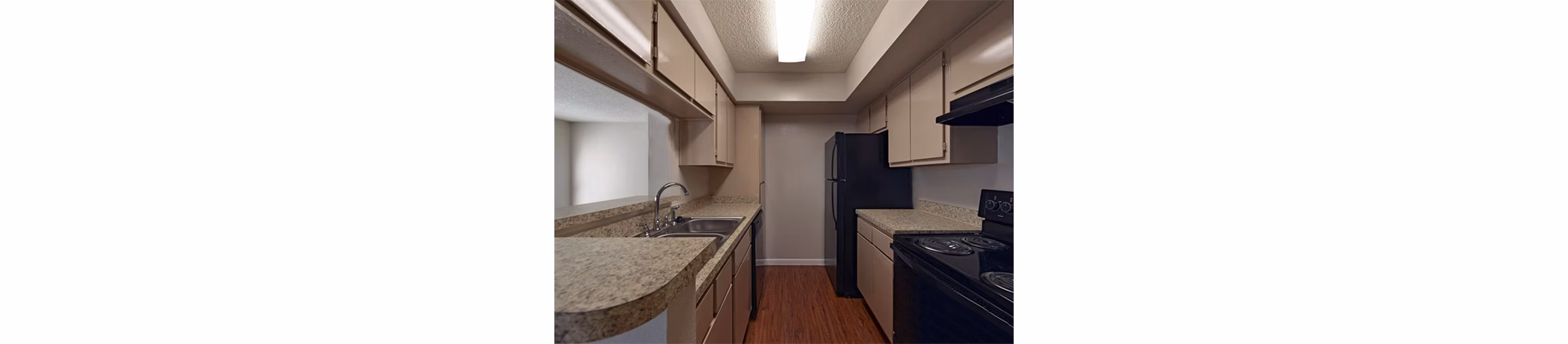 Modern kitchen with stainless steel appliances at Scotland Yard Apartments, featuring sleek countertops and ample storage