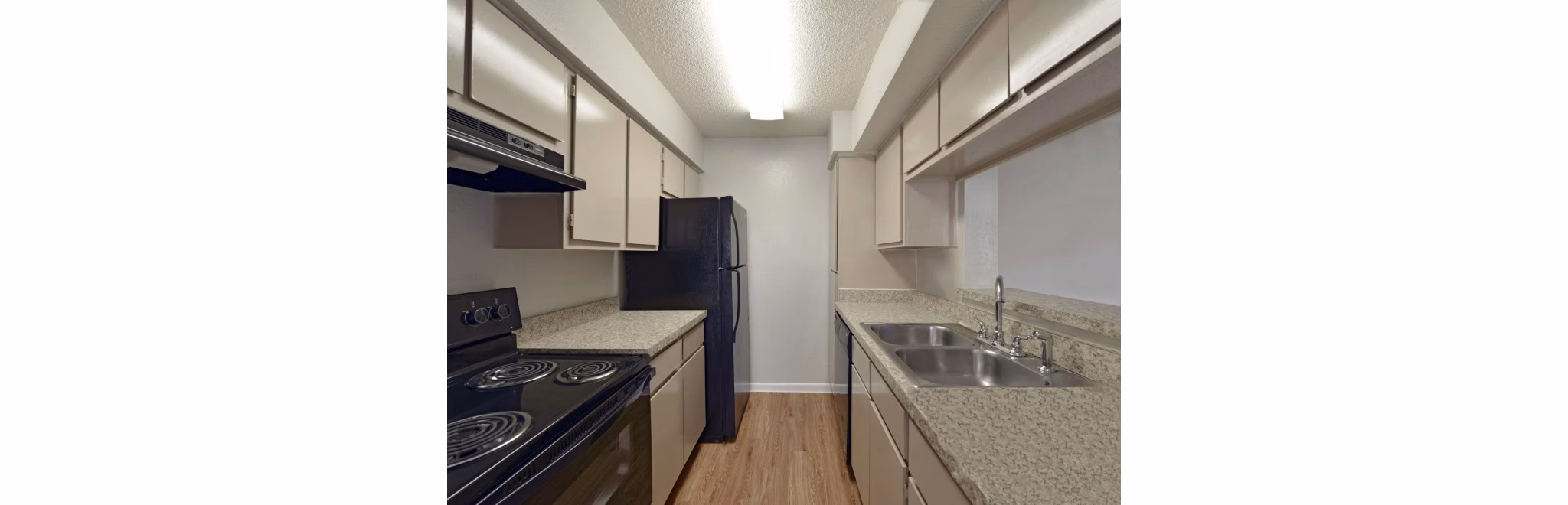 Modern kitchen with granite countertops and stainless steel appliances in Scotland Yard Apartments