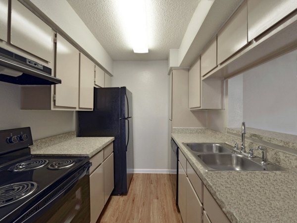 Modern kitchen with granite countertops and stainless steel appliances in Scotland Yard Apartments