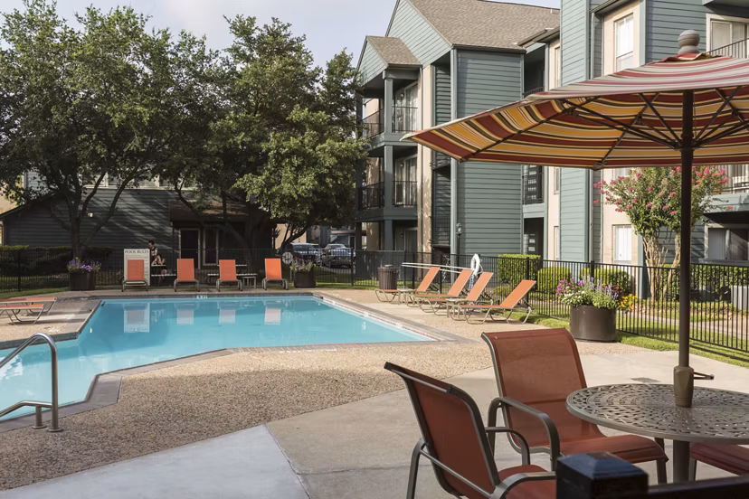 Serene outdoor pool at Scotland Yard Apartments with lounge seating and lush landscaping
