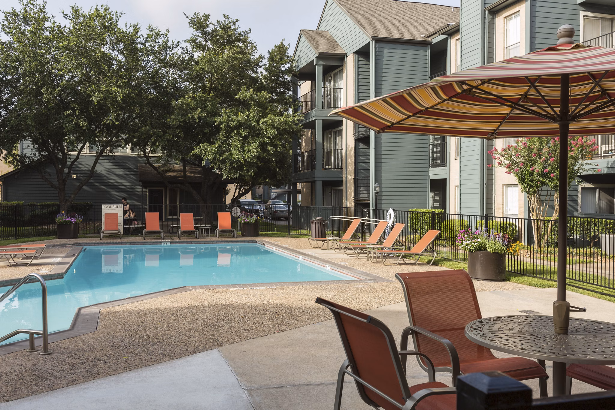 Serene outdoor pool at Scotland Yard Apartments with lounge seating and lush landscaping