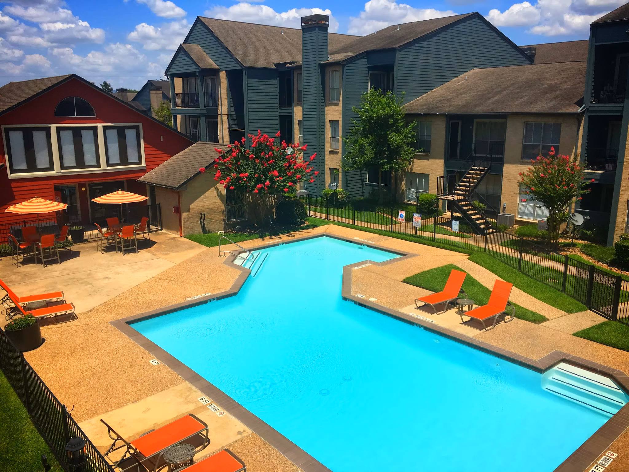 Outdoor heated pool at Scotland Yard Apartments with poolside seating and lush landscaping, offering luxury living in a serene setting