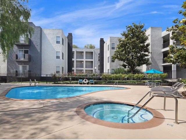 Resort-style pool at Canyon Crest Apartments with comfortable lounging areas and lush landscaping
