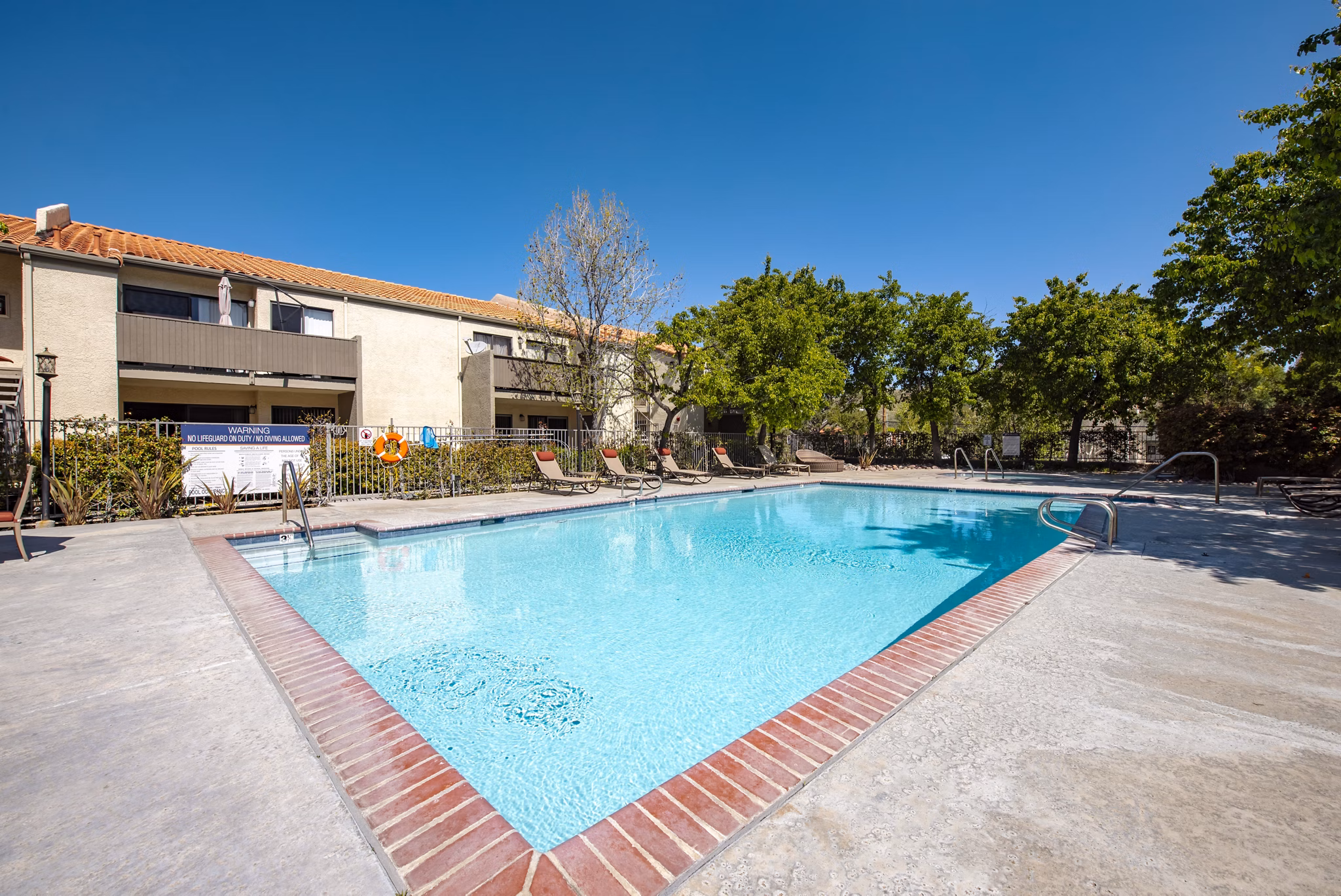 Relaxing pool area with spacious lounging deck at Canyon Ridge Apartments, offering luxury living in a serene environment