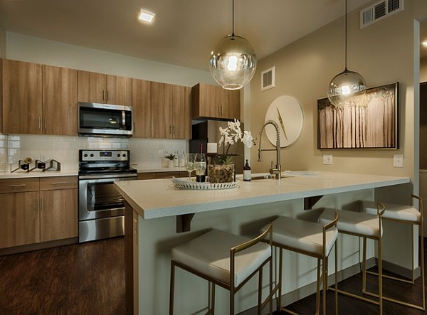 Modern kitchen featuring sleek countertops and stainless steel appliances at Summerly at Zanjero Apartments