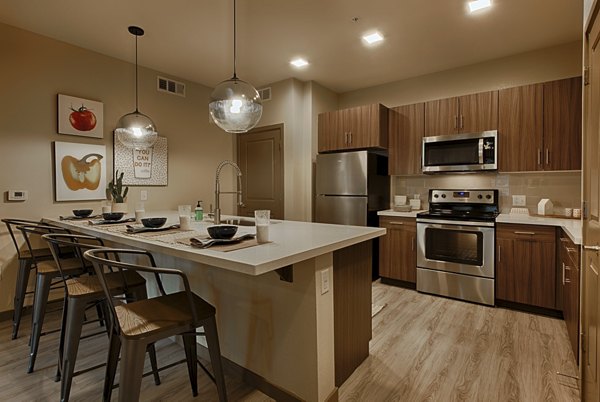 Modern kitchen with sleek countertops and stainless steel appliances at Summerly at Zanjero Apartments