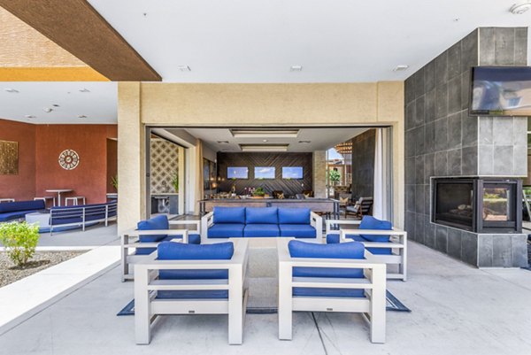 Chic outdoor patio at Summerly at Zanjero Apartments with comfortable seating and vibrant garden views