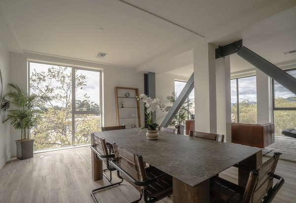 Elegant dining area with modern lighting and large windows at 47Hundred Apartments, a luxury Greystar community