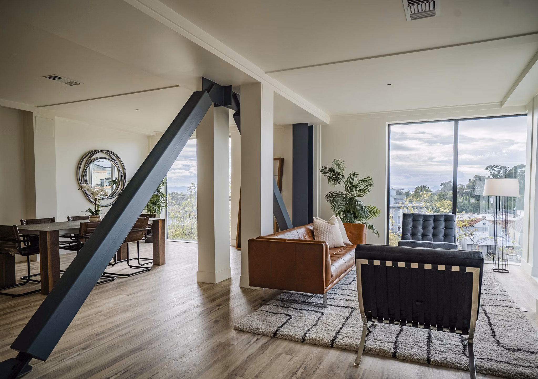 Modern living room with sleek furnishings and large windows at 47Hundred Apartments