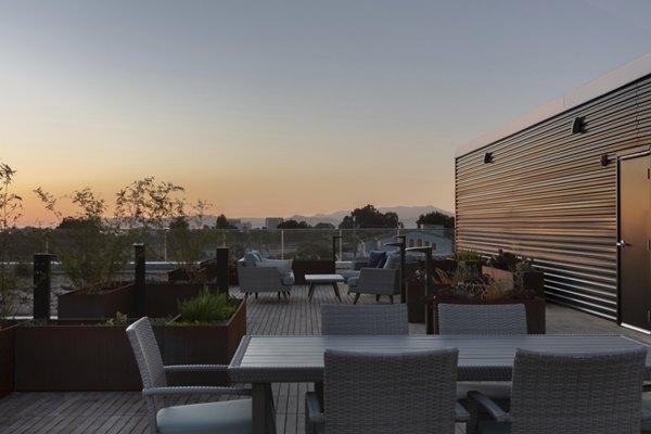 Stylish rooftop deck with seating and greenery at 47Hundred Apartments overlooking city skyline