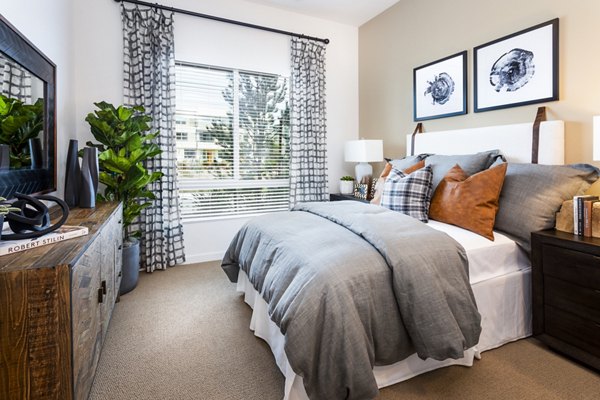 Rivue Apartments: Cozy bedroom with contemporary decor and ample natural light