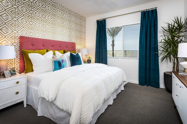 Elegant bedroom featuring stylish decor and large windows at Rivue Apartments, luxury living in a Greystar-managed community