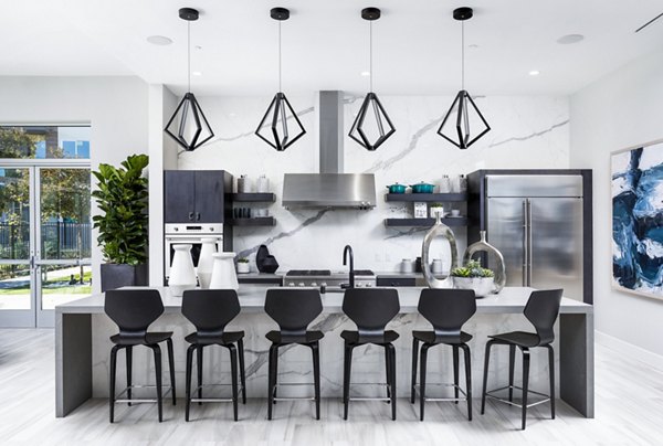 Clubhouse kitchen with modern appliances and seating at Rivue Apartments, perfect for community gatherings and casual dining experiences