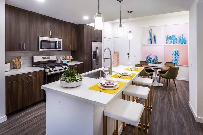 Modern kitchen with stainless steel appliances and granite countertops at Rivue Apartments