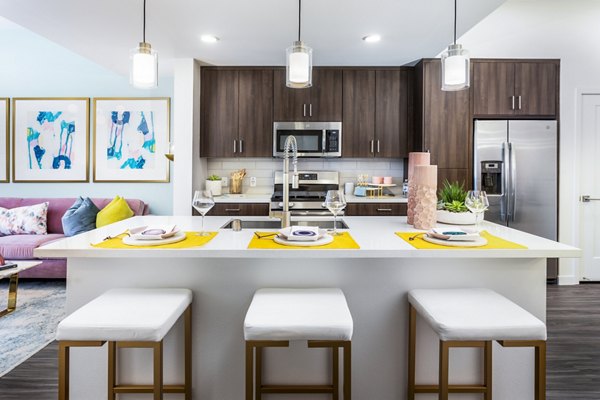 Modern kitchen with marble countertops and stainless steel appliances in Rivue Apartments, Greystar luxury community