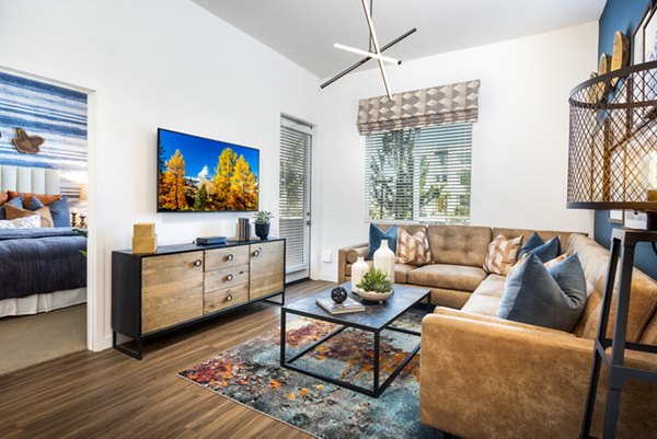 Bright living room with modern decor and large windows at Rivue Apartments, offering luxury living in Greystar's premier community