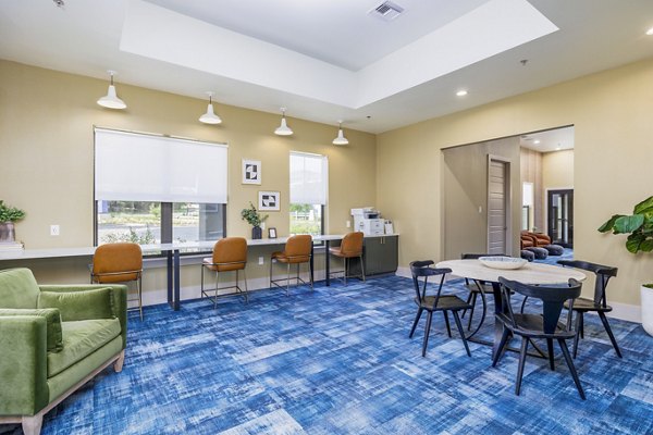 Clubhouse business center with modern workstations at The Monterra Apartments, ideal for meetings and remote work in a luxury setting
