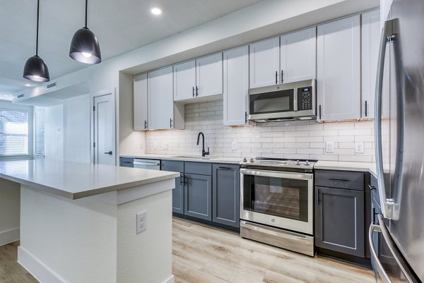 Modern kitchen with sleek countertops and stainless steel appliances at The Tobin Estate Apartments