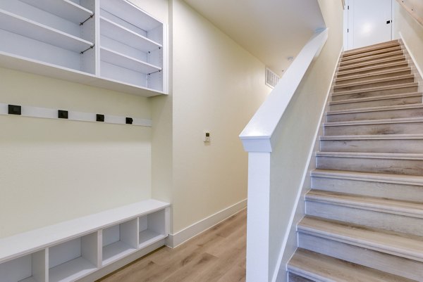 Spacious hallway with elegant staircase at The Tobin Estate Apartments, offering a luxurious living experience